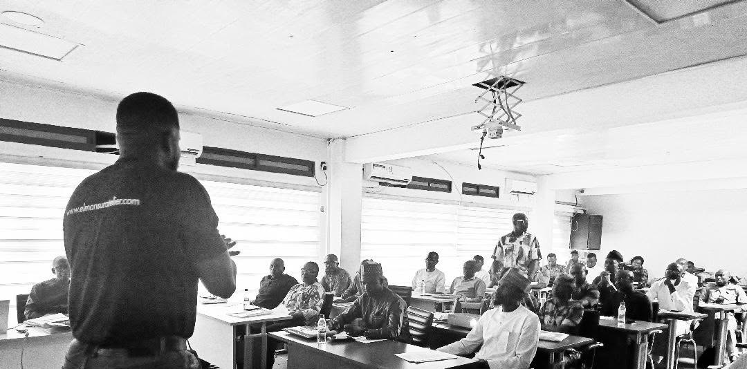 Victor leading a workshop in front of a room of professionals in Abuja