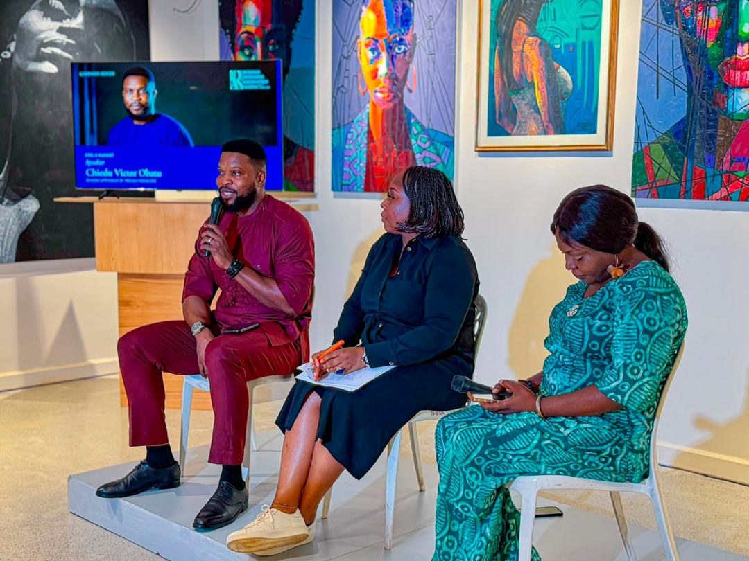 Victor speaking on a panel discussion at an industry event, with his name on the screen behind him