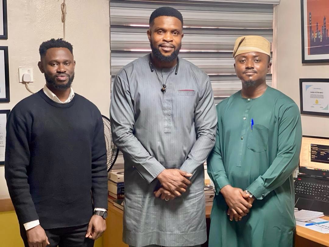 Victor standing with two colleagues during a mentorship meeting in an office
